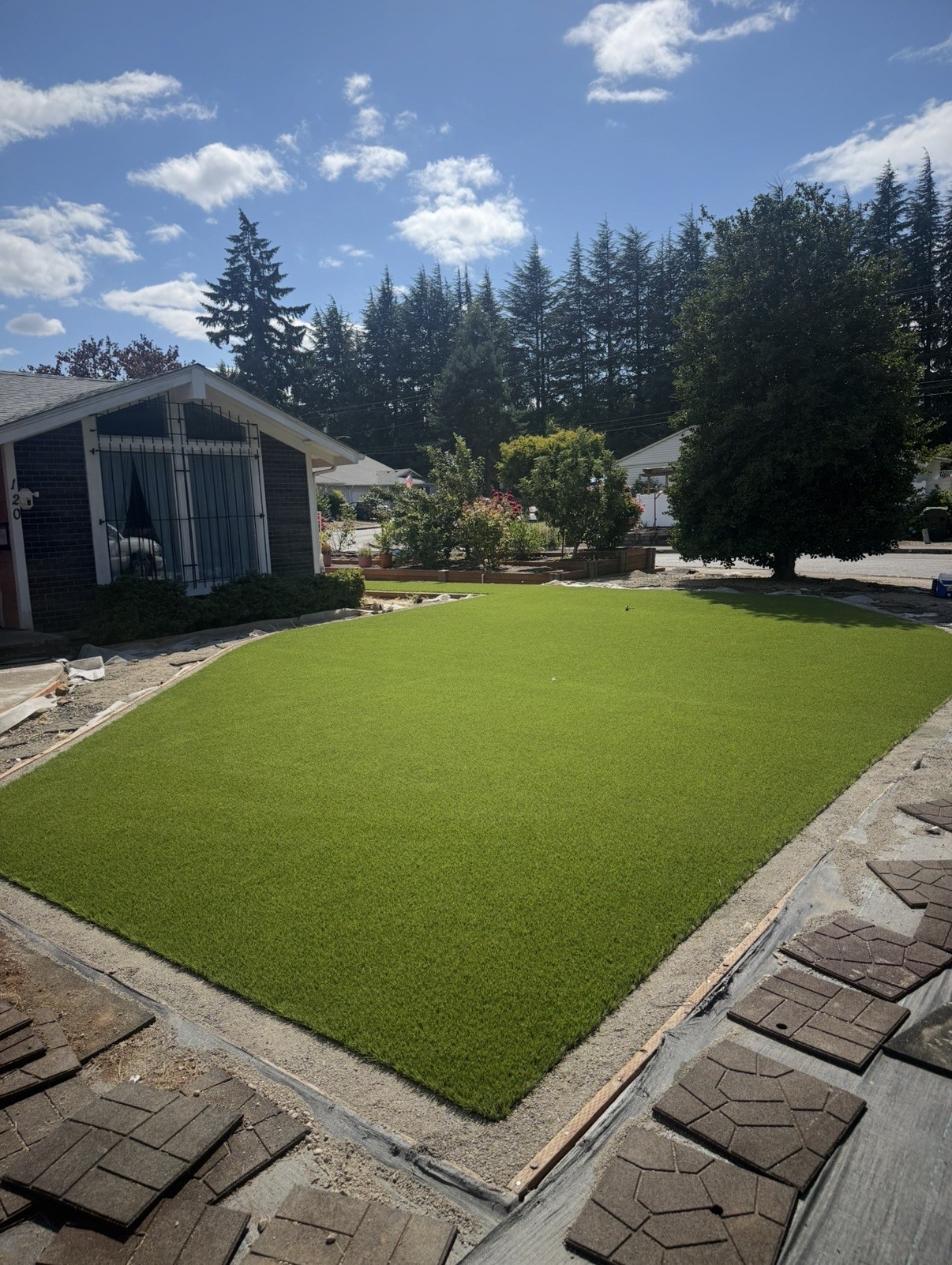 Artificial turf with a paver border in a backyard